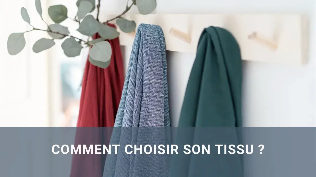 Trois tissus colorés (rouge, bleu à chevrons, vert) suspendus sur un portant. Le texte "COMMENT CHOISIR SON TISSU ?" apparaît en bas.