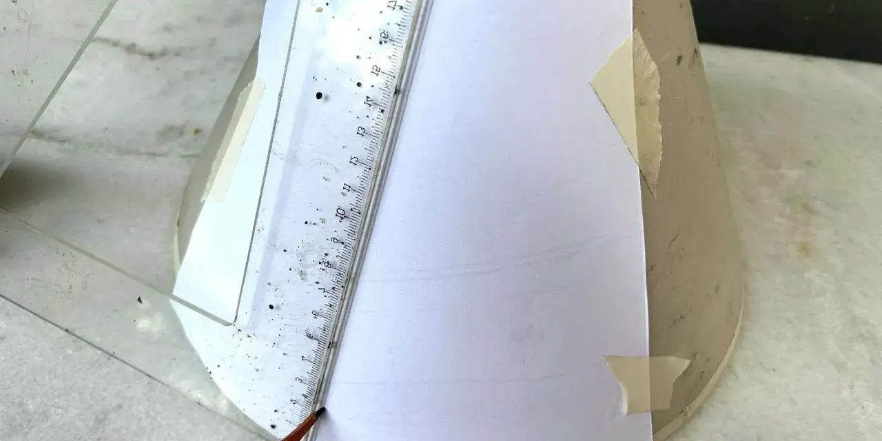 Un crayon et une règle mesurent un gabarit en papier pour un abat-jour DIY.