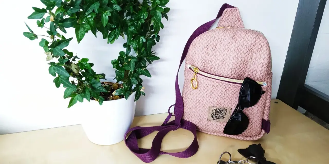 Sac à dos rose texturé, parfait pour une femme. Un patron sac à dos femme gratuit pour créer le vôtre. Lunettes de soleil et clés à proximité.