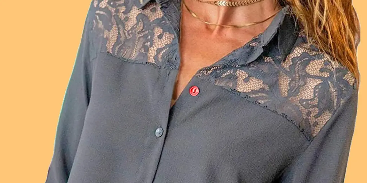 Chemise grise avec empiècements en dentelle sur les épaules. Le boutonnière fille est sur le côté gauche.