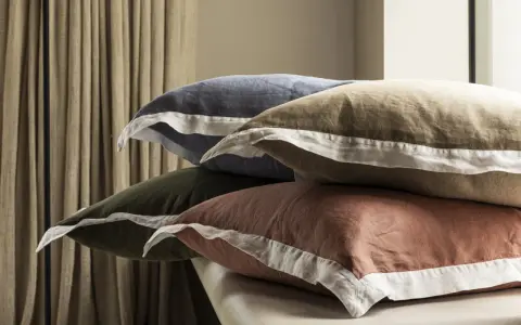 Pile de coussins aux couleurs douces, bleu, kaki, ocre, avec bordure blanche. Le percale de coton, c'est quoi ? Une matière douce et respirante.