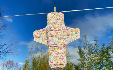 Serviette hygiénique lavable à fleurs, suspendue pour sécher. Un tuto pour la fabriquer soi-même.