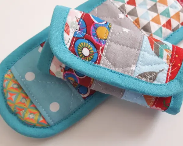 Idée couture : tissu matelassé aux motifs géométriques et floraux, bordé de biais turquoise. Parfait pour un manique ou un dessous de plat original.