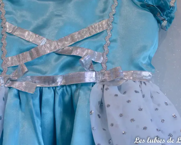 Détail d'une robe de princesse bleue avec laçage argenté. Un patron robe princesse gratuit à télécharger pour créer la magie.