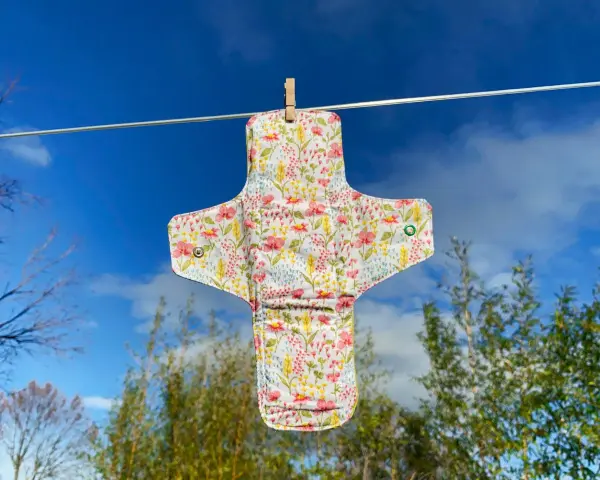Serviette hygiénique lavable à fleurs, suspendue pour sécher. Un tuto pour la fabriquer soi-même.