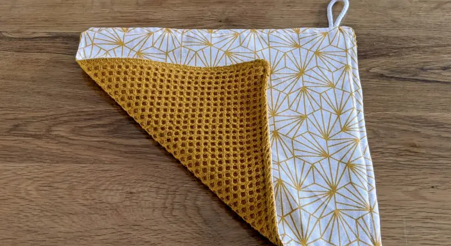 Tuto essuie-tout lavable sans pression : un tissu blanc à motifs géométriques dorés et un tissu éponge moutarde.