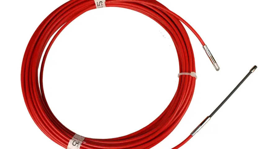 Un passe-fil rouge enroulé, prêt à être utilisé pour guider des câbles.