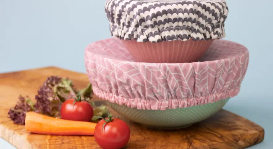 Trois couvre-plats en tissu avec des motifs différents, empilés sur des bols. Un tuto pour les réaliser soi-même.