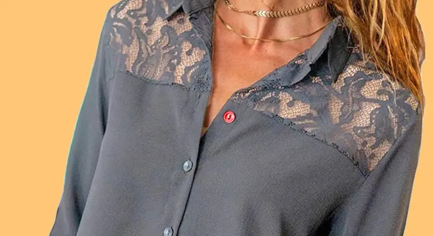 Chemise grise avec empiècements en dentelle sur les épaules. Le boutonnière fille est sur le côté gauche.