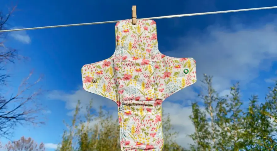 Serviette hygiénique lavable à fleurs, suspendue pour sécher. Un tuto pour la fabriquer soi-même.