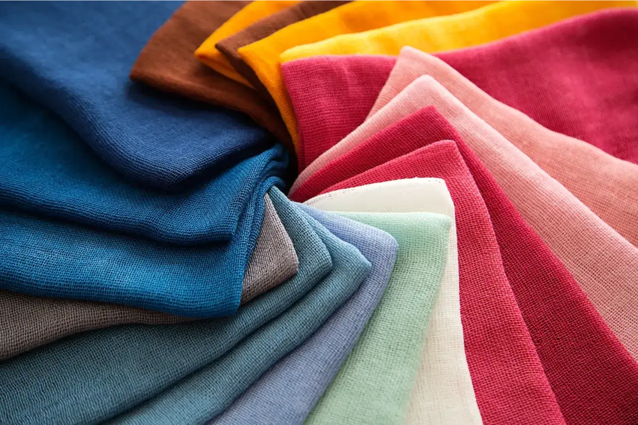Échantillons de tissu pour chemise aux couleurs vives, disposés en éventail. Bleu, marron, jaune, rose, rouge, vert menthe et blanc.