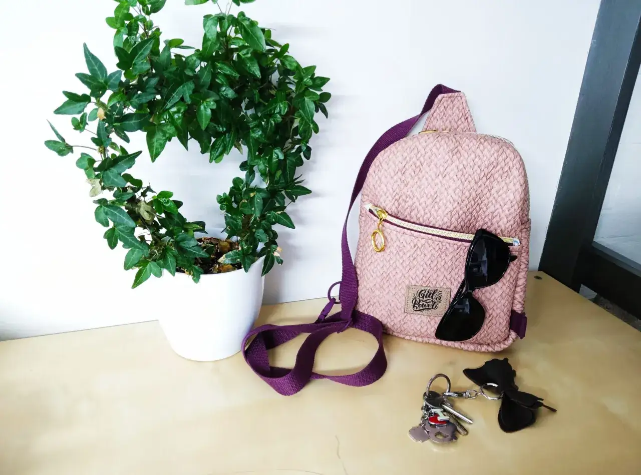 Sac à dos rose texturé, parfait pour une femme. Un patron sac à dos femme gratuit pour créer le vôtre ! Lunettes de soleil et clés à proximité.