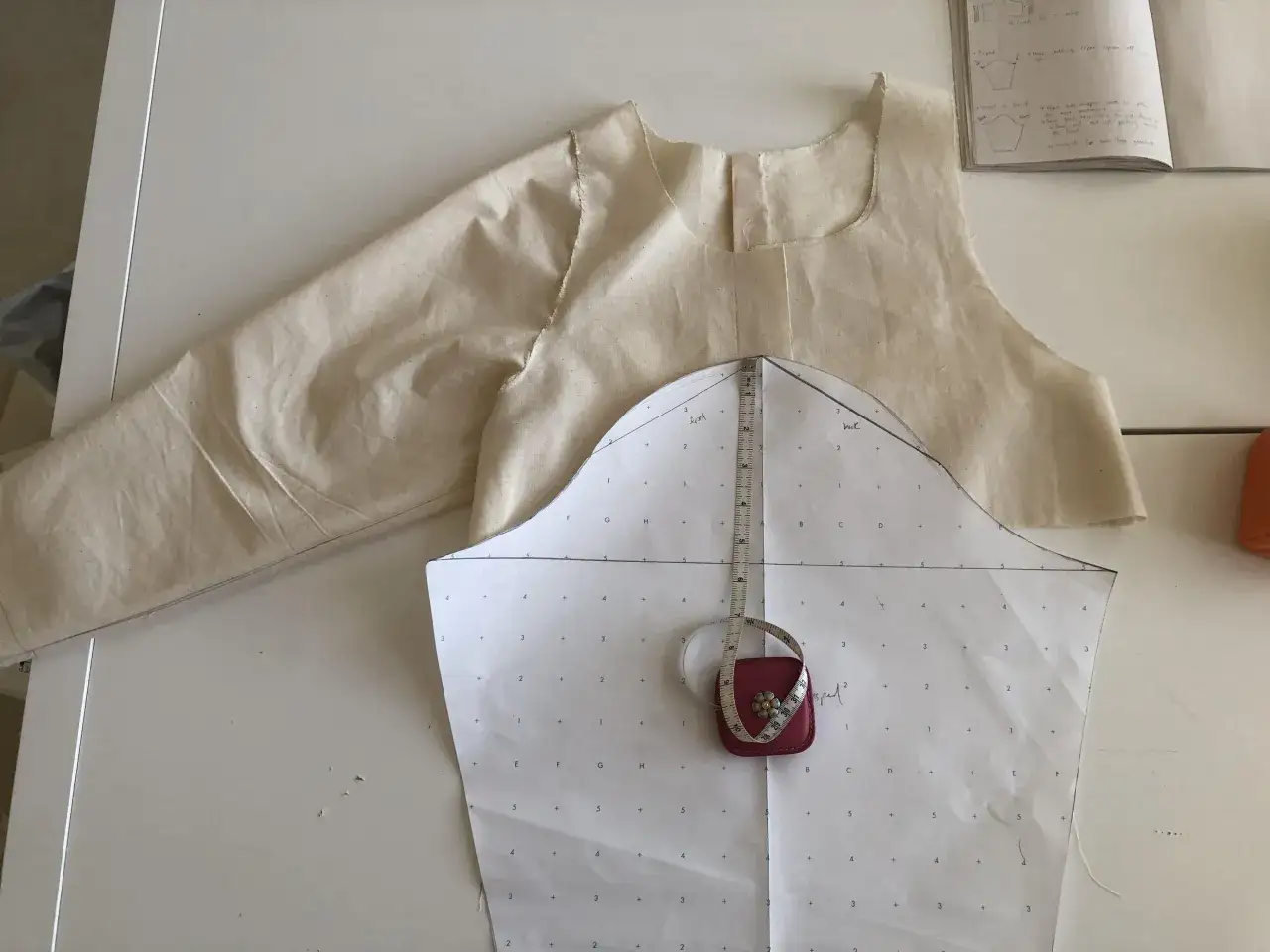 Patron de couture pour une manche montée, avec un ruban à mesurer posé sur le papier.