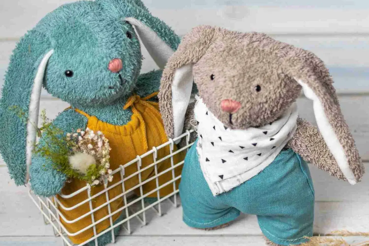 Deux adorables lapins en peluche, l'un bleu et l'autre gris, prêts à être cousus grâce à un patron doudou gratuit à imprimer.