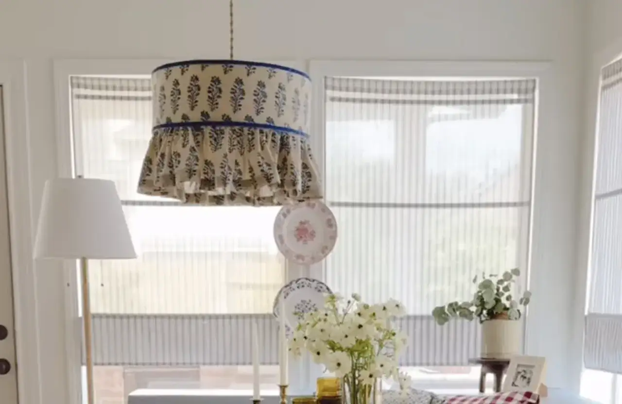 Un abat-jour suspendu avec un motif floral bleu et des volants, une excellente idée déco abat jour pour une ambiance champêtre.